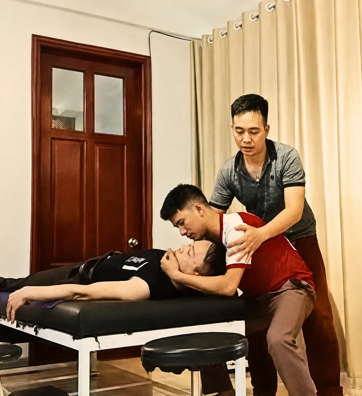 Nguyễn Chính sửa vị trí tay và hướng lực cho học viên trị liệu